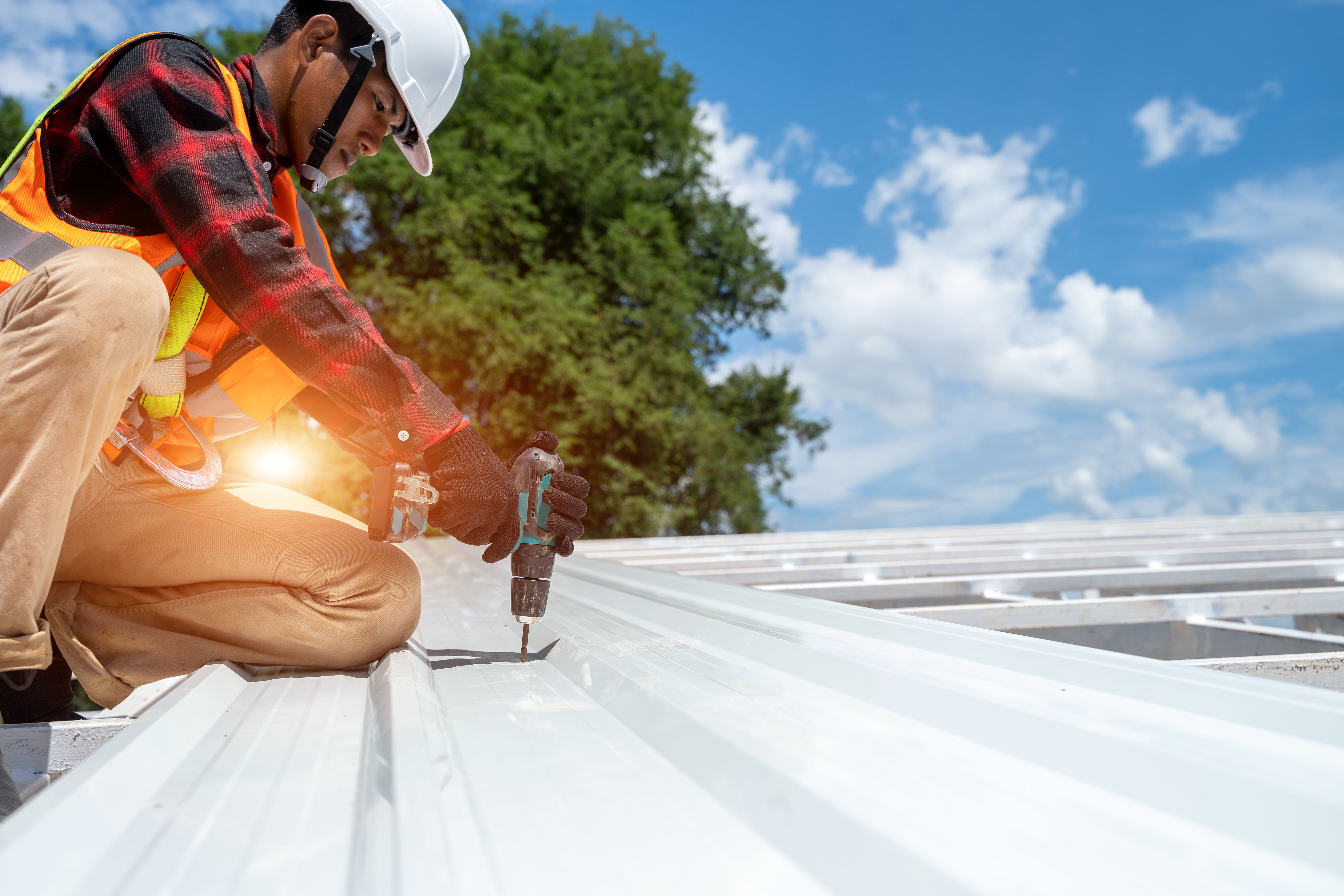 Technician installing standing-seam metal roofing